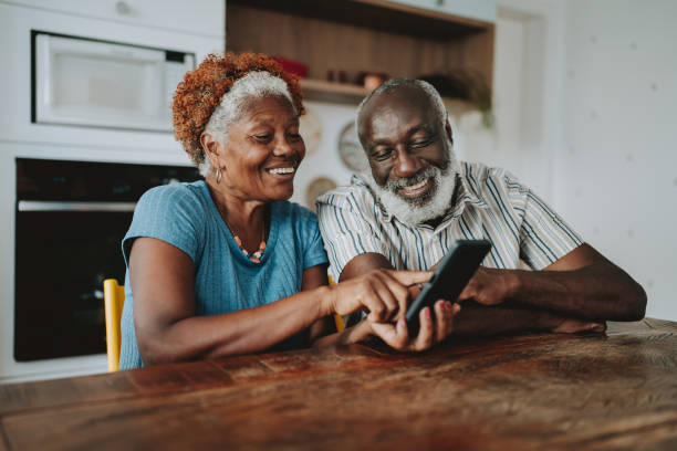 Curso gratuito ensina pessoas 50+ a usar celular e redes sociais em Divinópolis Portrait senior couple using smartphone at home